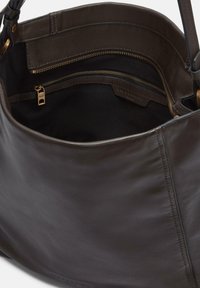 Borsa a mano in pelle marrone scuro con apertura superiore, che mostra la fodera interna in tessuto nero e una piccola tasca con zip e tirazip dorato.