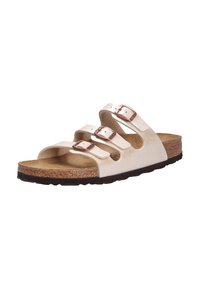 Beige lädersandaler med tre justerbara remmar, metallspännen och en fotbädd av kork. Texturerad gummisula för grepp.