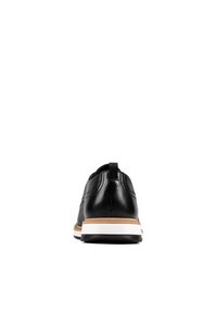 Chaussure en cuir noir avec une texture lisse, semelle intermédiaire blanche et un accent marron le long de la semelle. Comprend une languette à l'arrière pour un enfilage facile.