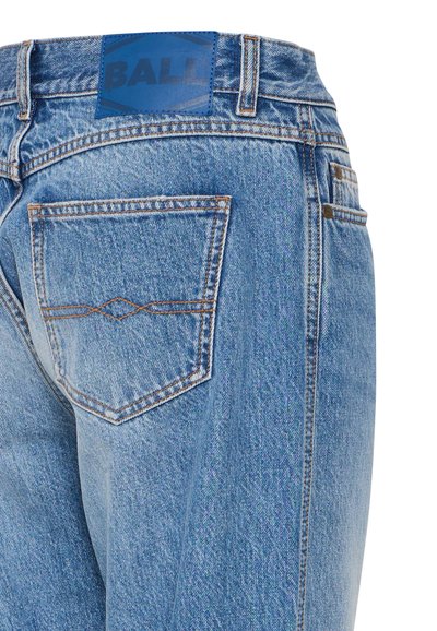 Ljusblå denimjeans med en läderblå etikett som läser "BALL" på midjan, med kontrasterande sömmar och detaljerad bakficka.