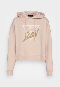 Felpa corta rosa chiaro con cappuccio regolabile, caratterizzata da un logo bianco triangolare e da un testo dorato "ICON" sul davanti.