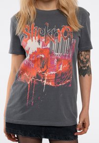 Grey cotton t-shirt featuring a colorful graphic design with "Slipknot" text, barcode elements, and abstract patterns in orange and pink.