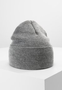 Gorro de punto gris con una textura suave, que presenta una parte superior cónica y un puño acanalado ajustado. Acabado liso con detalles de costura sutiles.