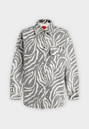 Chemise à manches longues boutonnée avec imprimé zèbre gris et blanc, col pointu et poche avant à rabat sur fond uni.