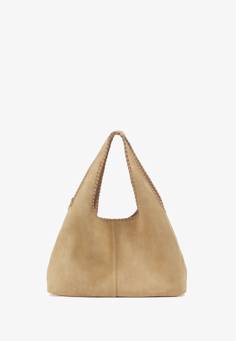 Sac cabas en daim souple couleur beige clair avec larges anses et surpiqûres décoratives sur les bords, présenté sur un fond blanc uni.
