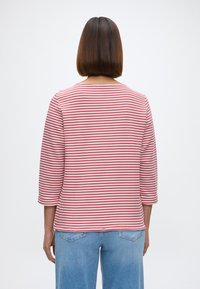 Μακρυμάνικη ριγέ μπλούζα σε ροζ και άσπρο, με στρογγυλή λαιμόκοψη και τρία τέταρτα μανίκια, φτιαγμένη από απαλό βαμβακερό μείγμα.