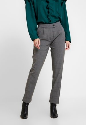 Pantalons à carreaux gris avec une coupe ajustée, dotés d'une fermeture à bouton, de plis avant et d'une coupe à la cheville, associés à une chemise verte.
