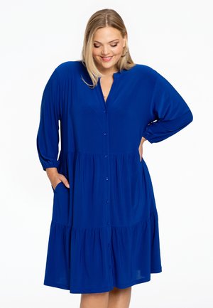 Blaues, knielanges Kleid mit knopflosem Vorderteil, V-Ausschnitt und gestuftem Rock. Hergestellt aus weichem Stoff mit langen, puffartigen Ärmeln und seitlichen Taschen.