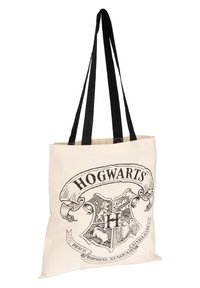 Canvas tote bag in beige with black handles; features Hogwarts crest design, including a shield and decorative text.