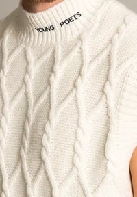 Bílý pletený svetr s kabelkovým vzorem, s vysokým límcem a nápisem "YOUNG POETS" černou barvou na výstřihu.