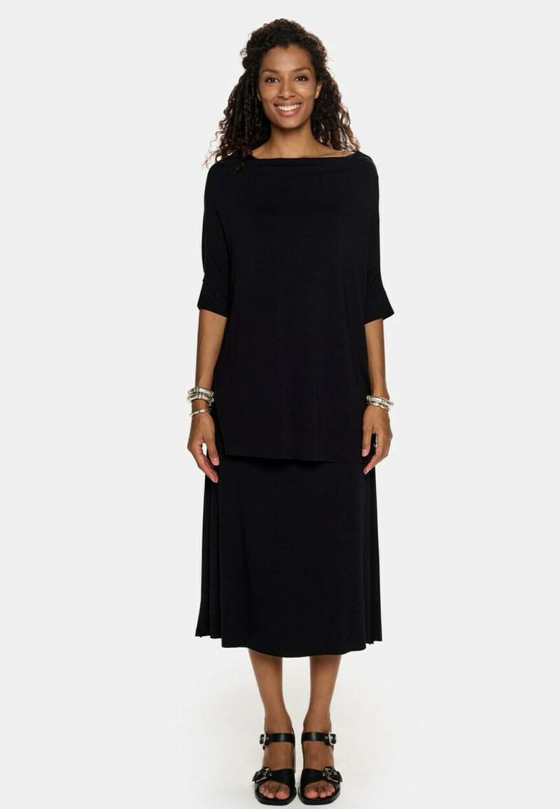 Czarna dwuczęściowa sukienka z luźno dopasowanym tunikowym topem z rękawami 3/4 oraz spódnicą sięgającą do pełnej długości. Gładka, teksturowana tkanina.