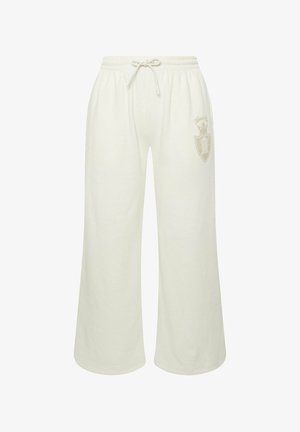 Jasno beżowe długie spodnie dresowe o szerokich nogawkach z elastycznym pasem i sznurkiem. Posiadają subtelną logo w jaśniejszym odcieniu na lewej biodrze.