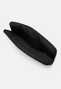 Carteira de tecido preto com fecho éclair, apresentando um interior espaçoso com dois compartimentos e uma textura suave. Sem detalhes externos.