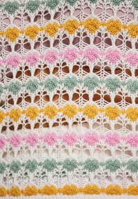 Model de dantelă tricotată multicolor, cu secțiuni verzi, roz, galbene și albe, având un design texturat, cu o țesătură deschisă.