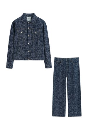 Veste en denim et jean droit bleu foncé avec motif de texte répétitif et boutons blancs.