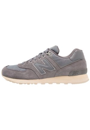 Gray suede and mesh New Balance sneaker with lace-up front and beige rubber sole, shown in side view.