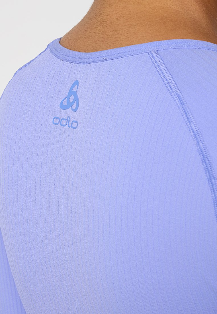 Helles lila Odlo Sporttop mit gerippter Textur, Rundhalsausschnitt und Logo auf dem Rücken. Glattes Material mit flachen Nähten.