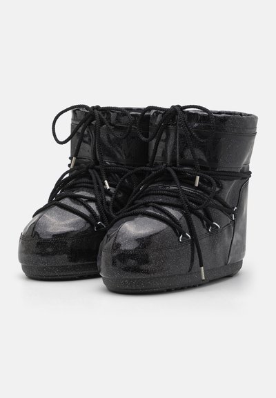 Black ankle boots made of glossy material with a textured rubber sole, featuring black laces, silver hardware, and glitter accents.