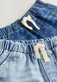 Zwei Paare Denim-Shorts mit elastischen Taillenbündchen, eines in Dunkelblau und eines in Hellblau, jeweils mit einer weißen Kordel. Sichtbare Details in strukturiertem Stoff.