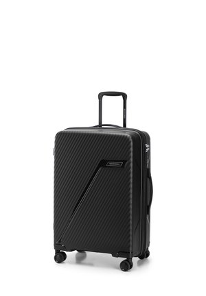 Hard-shell black suitcase with a textured ribbed surface, retractable handle, and four wheels for mobility. Features a logo on the side.
