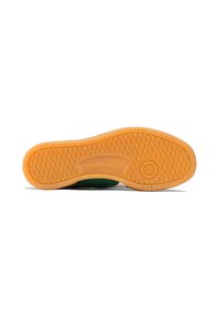 Semelle en caoutchouc avec un motif texturé orange ; présente un logo circulaire et le marquage "Reebok" près du talon.