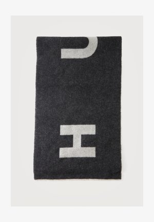 Écharpe rectangulaire en laine noire avec de grandes lettres blanches "C" et "H" partiellement visibles sur un fond blanc.
