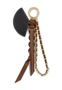 Nahkane võtmehoidja musta nahkaktsendi, pruuni rihmade ja kuldsete detailidega. Omab punutud ahelat ja sarnaseid tupsulaadseid detaile.