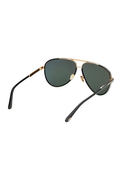 Lunettes de soleil aviateur noires et dorées avec des verres teintés verts et des branches fines noires sur fond blanc.