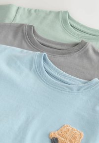 Three crewneck sweatshirts in light blue, gray, and mint green stacked, with a beige textured car patch on the blue sweatshirt.