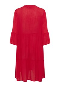 Robe rouge, longueur genou avec un design en étages, manches évasées et col froncé. Fabriquée en tissu léger et translucide.