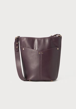 Sac seau en cuir bordeaux avec bandoulière ajustable, doté de deux poches avant et de quincaillerie dorée. Texture lisse, forme structurée.