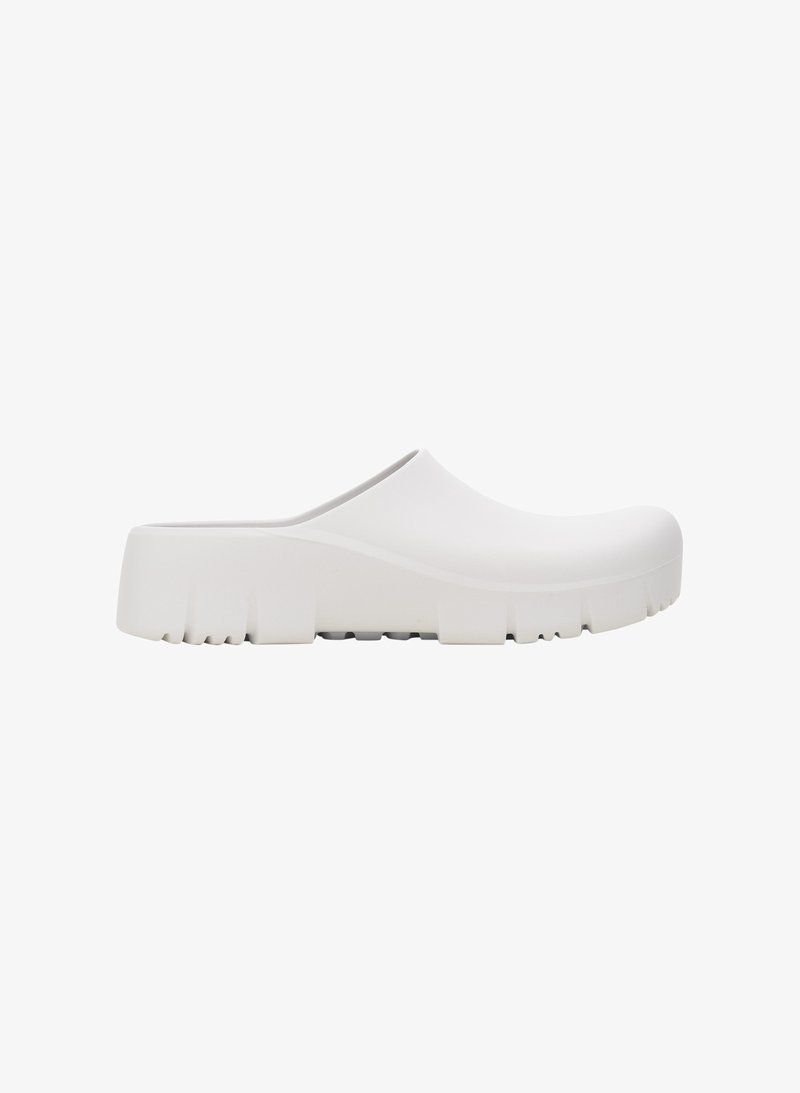 Sabots en caoutchouc blancs avec un design épuré, un bout rond et une semelle texturée épaisse. Style à enfiler avec un dos bas.