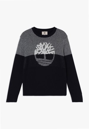 Sort og gråstrikket sweater med en stor hvid trælogo centreret på brystet, med lange ærmer og rund hals.