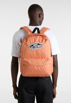 Mochila naranja de Vans con logo, correas acolchadas, compartimento principal con cremallera y bolsillo frontal. Tejido suave y forma rectangular.