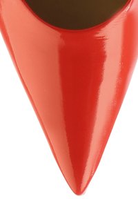 Red patent leather stiletto heel with a pointed toe. The surface is glossy, reflecting light, highlighting the sleek design.