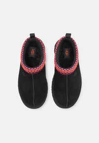 Svarta mockasinskor med en färgglad broderad krage och mjukt foder, designade för komfort med en platt gummisula.