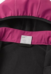 Intérieur de veste en polaire noire avec une doublure de capuche rose. Comprend une étiquette avec de la place pour la personnalisation. Détails de couture contrastants visibles.