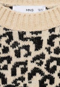 Beige pletený svetr s černým leopardím potiskem. Hladký žebrovaný límec a pletená textura. Značková etiketa viditelná uvnitř límce.