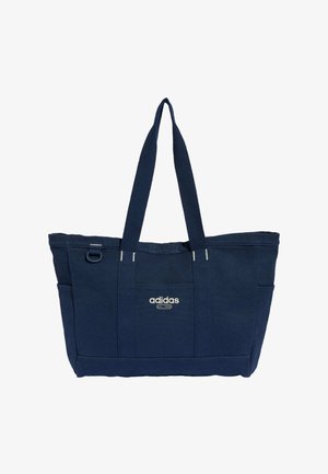 Marineblaue Adidas Tragetasche mit zwei langen Griffen, Frontlogo, Seitentaschen und eingenähtem rechteckigem Design.
