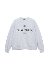 Svetlo siva jopa z okroglim ovratnikom, z napisi "NEW YORK" in grafičnimi poudarki v temnem tisku. Mehka tekstura z rebrastimi manšetami in spodnjim robom.
