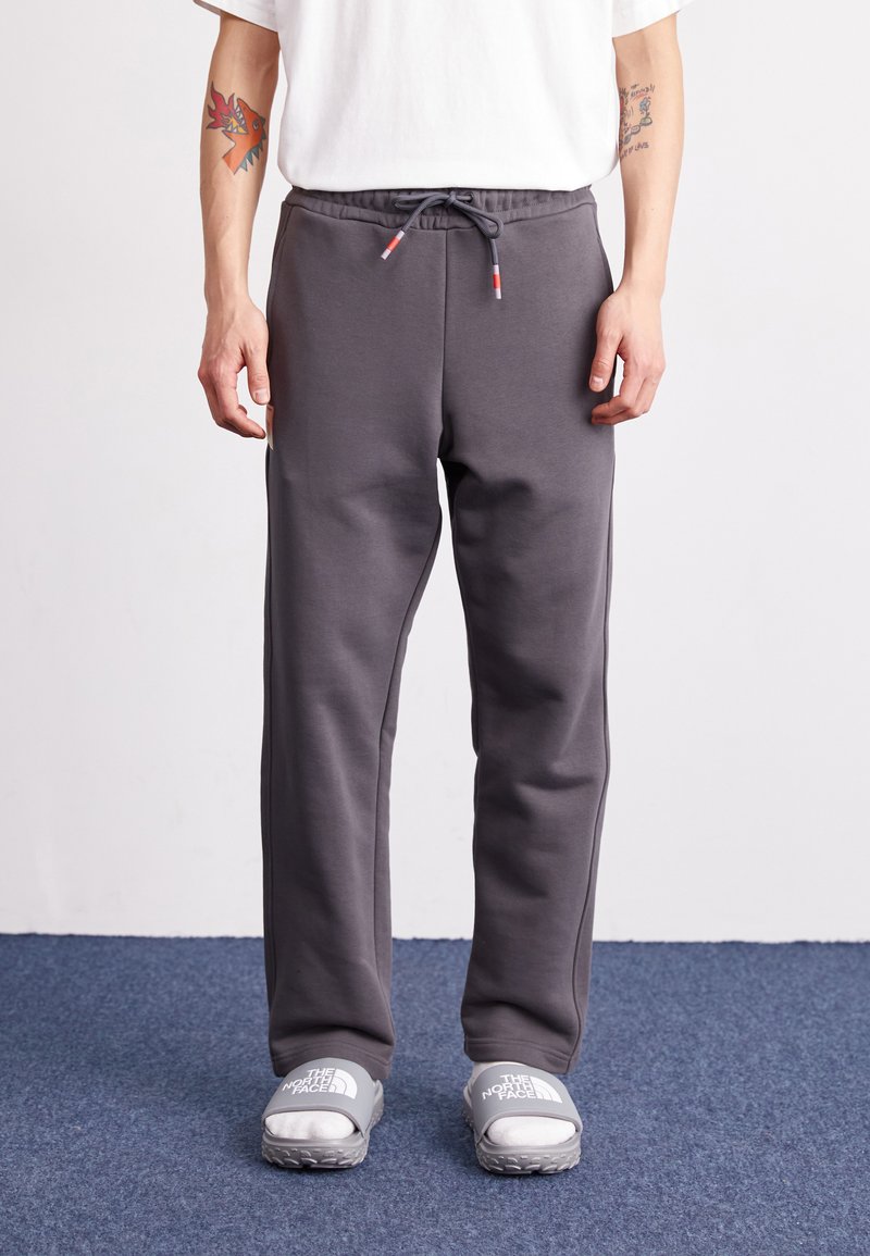 Graue Sweatpants mit einem elastischen Bund und Kordelzug, ausgestattet mit Seitentaschen und einer weichen, glatten Textur. Lässige Passform, die für Komfort sorgt.