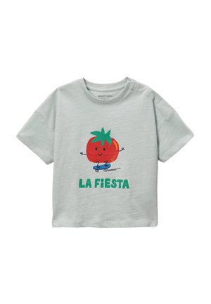 T-shirt à manches courtes vert clair avec un graphique ludique de tomate sur un skateboard et le texte "LA FIESTA" en vert. Tissu en coton doux.