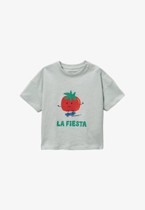 T-shirt à manches courtes vert clair avec un graphique ludique de tomate sur un skateboard et le texte "LA FIESTA" en vert. Tissu en coton doux.