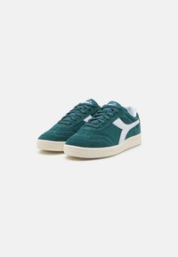 Sneaker in suede teal con dettagli bianchi, punta rotonda e design con lacci. Presentano una superficie texturizzata e una suola in gomma per una migliore aderenza.