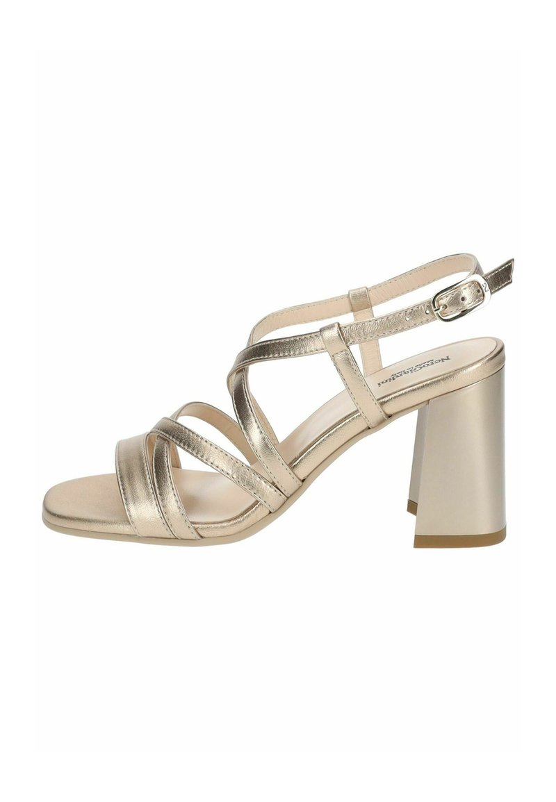 Metallic gold heeled sandal with multiple crisscross straps and a square block heel. Smooth texture with a subtle sheen. Adjustable ankle strap.