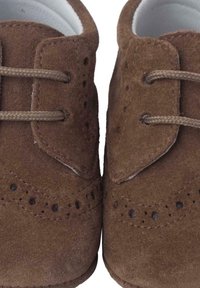 Scarpe in suede marrone con punta arrotondata, caratterizzate da dettagli perforati intricati e due chiusure con lacci per una vestibilità sicura.