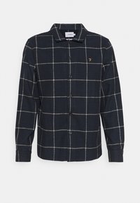 Camicia a quadri blu navy con bottoni realizzata in tessuto testurizzato; presenta un motivo a griglia bianca e un piccolo emblema dorato sul petto. Chiusura con bottoni.