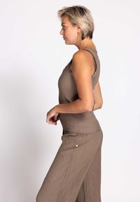 Brown, ribbed tank top with textured fabric and a fitted design, paired with matching wide-leg trousers featuring snap details.