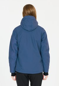 Blå huva jacka med en slät yta, elastiska muddar och rundad nederkant. Har en enkel design utan synliga logotyper eller mönster.