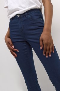 Štíhlé modré džíny z denimu s středním pasem, které mají jedno zapínání na knoflík a poutka na opasek. Hladký povrch a klasický design.